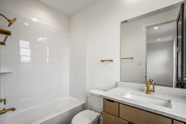 Bathroom with gold hardware in 221 West 23rd Street Houston TX from stonefield homes